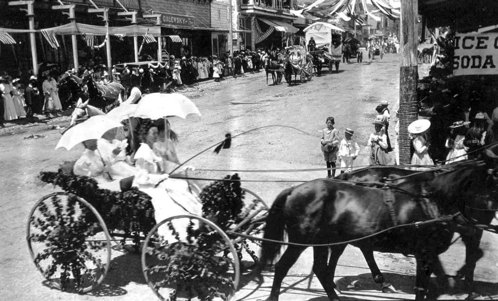 Historic parade with horse-drawn carriage and spectators
