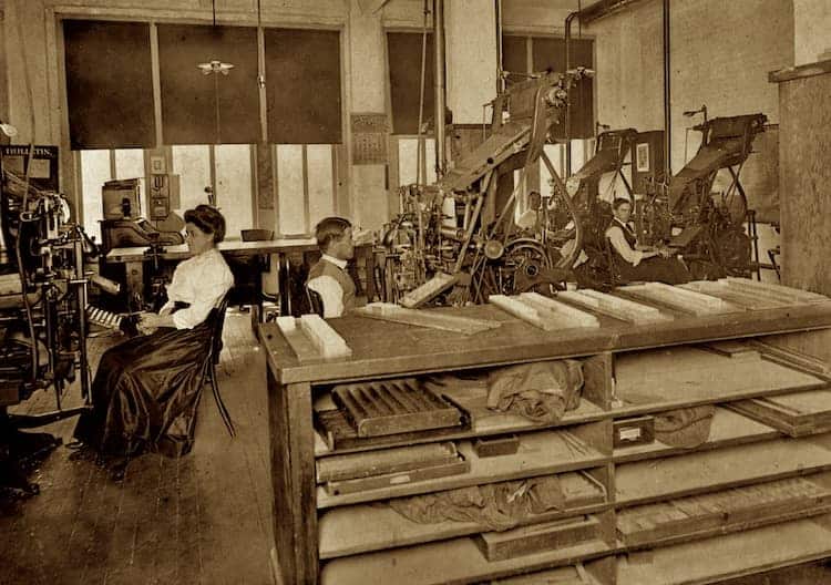 Workers operating printing machines in old print shop