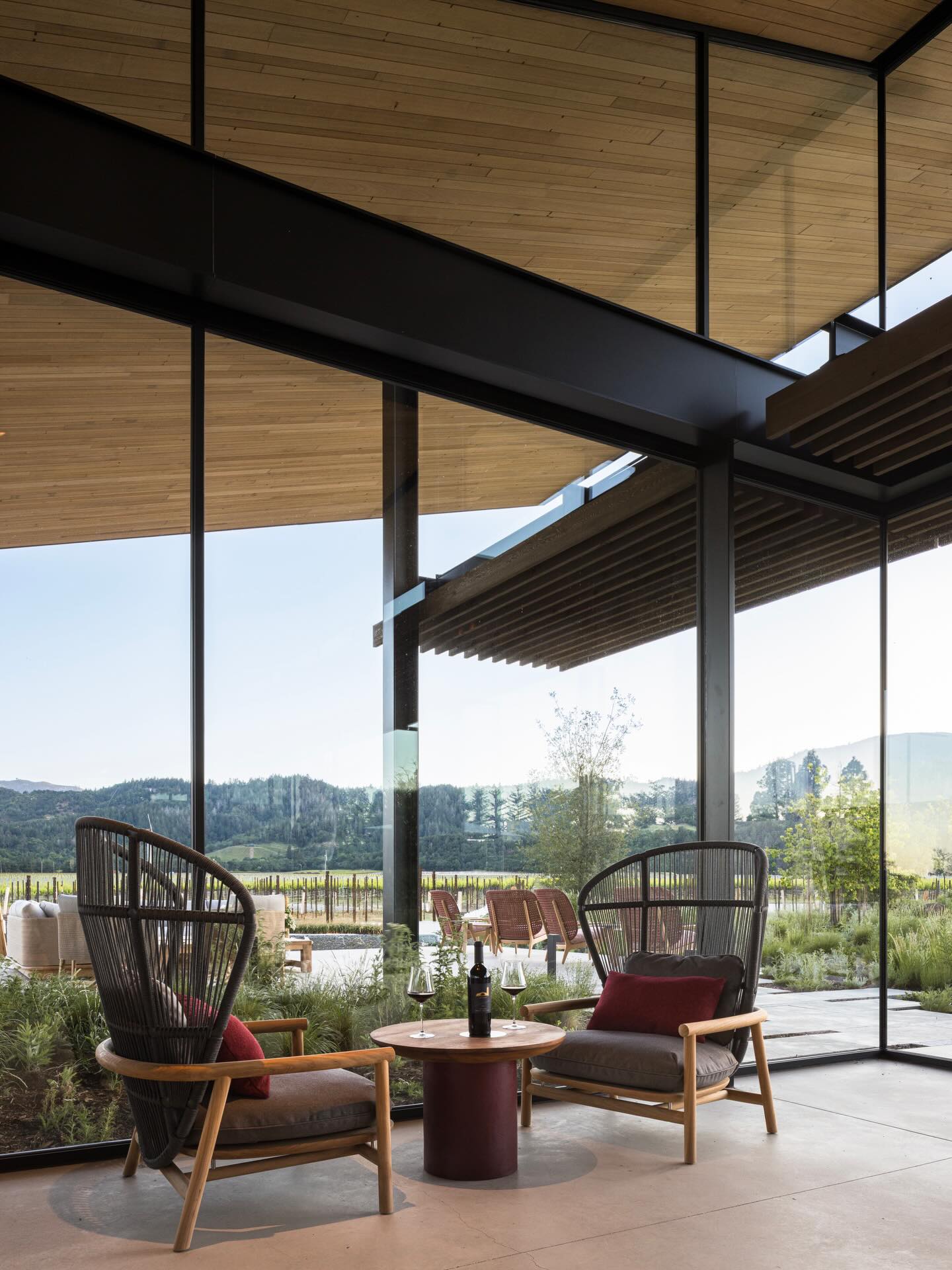 Modern glass living room overlooking vineyard landscape
