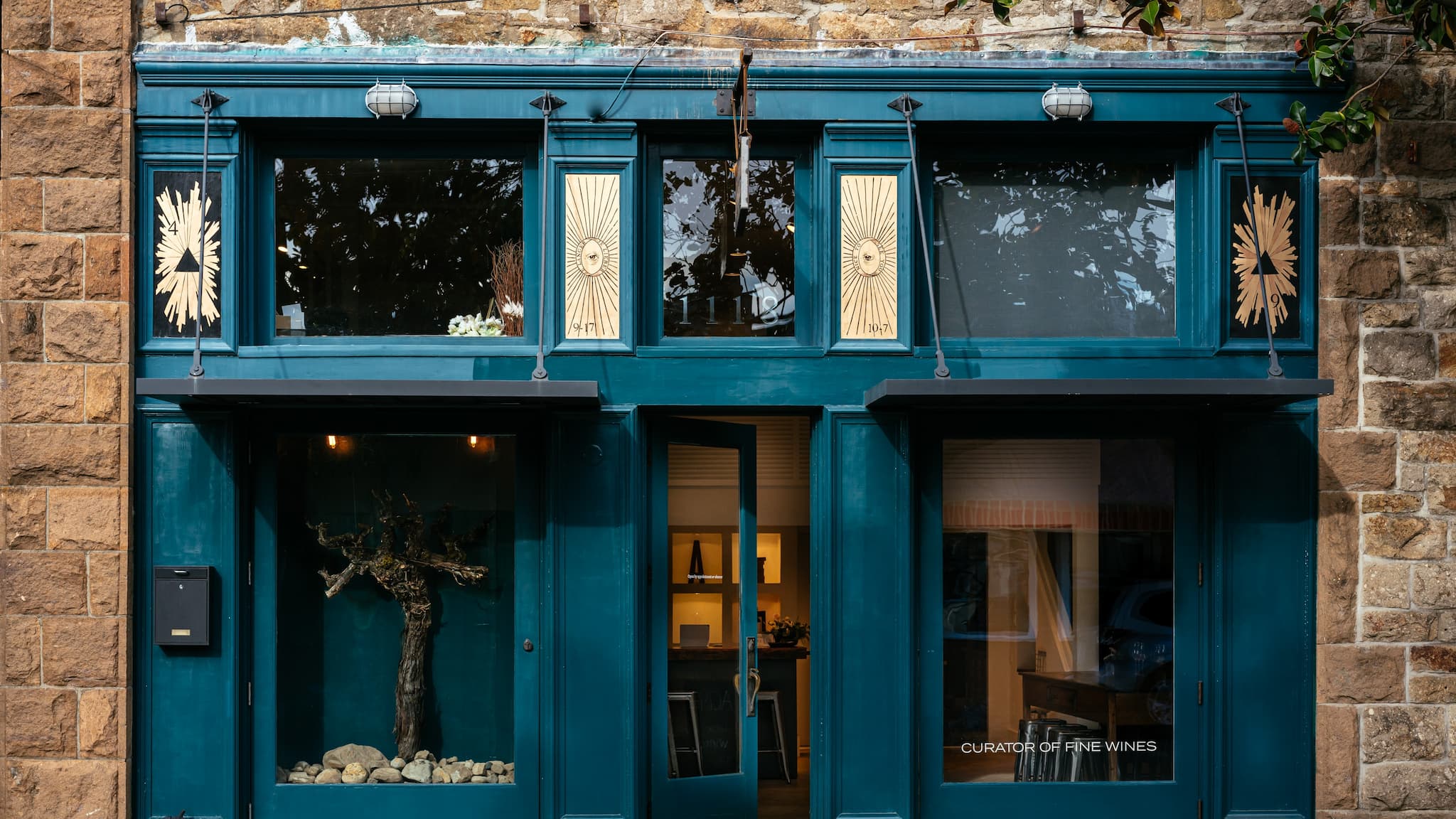 Teal storefront with decorative sunburst windows