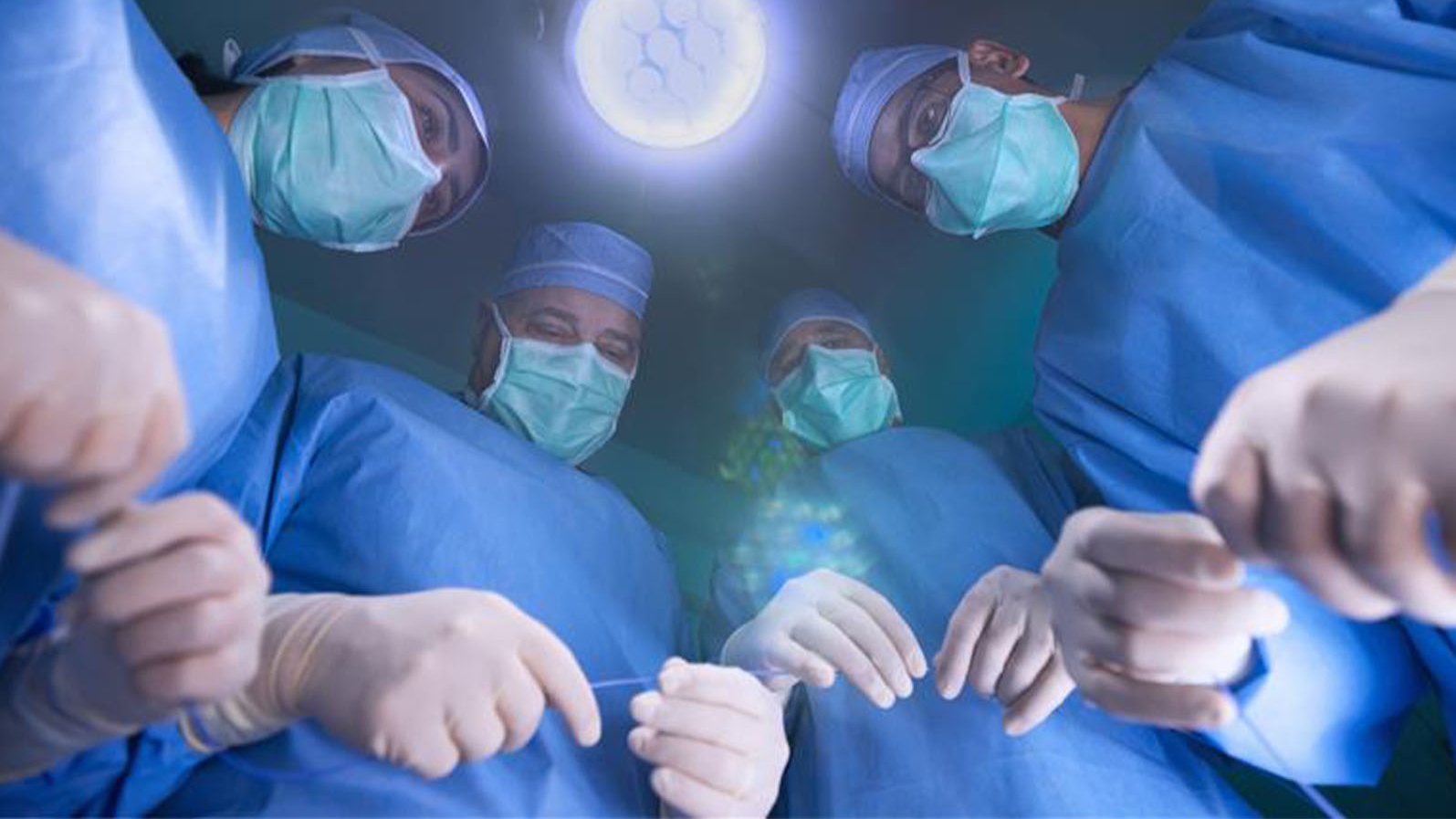 Surgeons prepare for operation in surgical room.