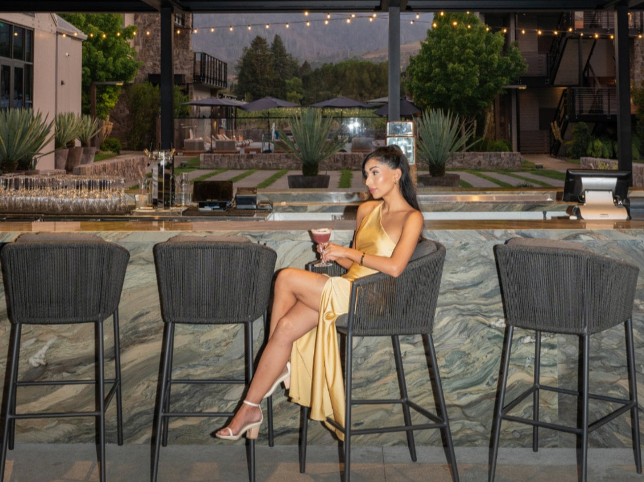 Woman in gold dress at outdoor bar