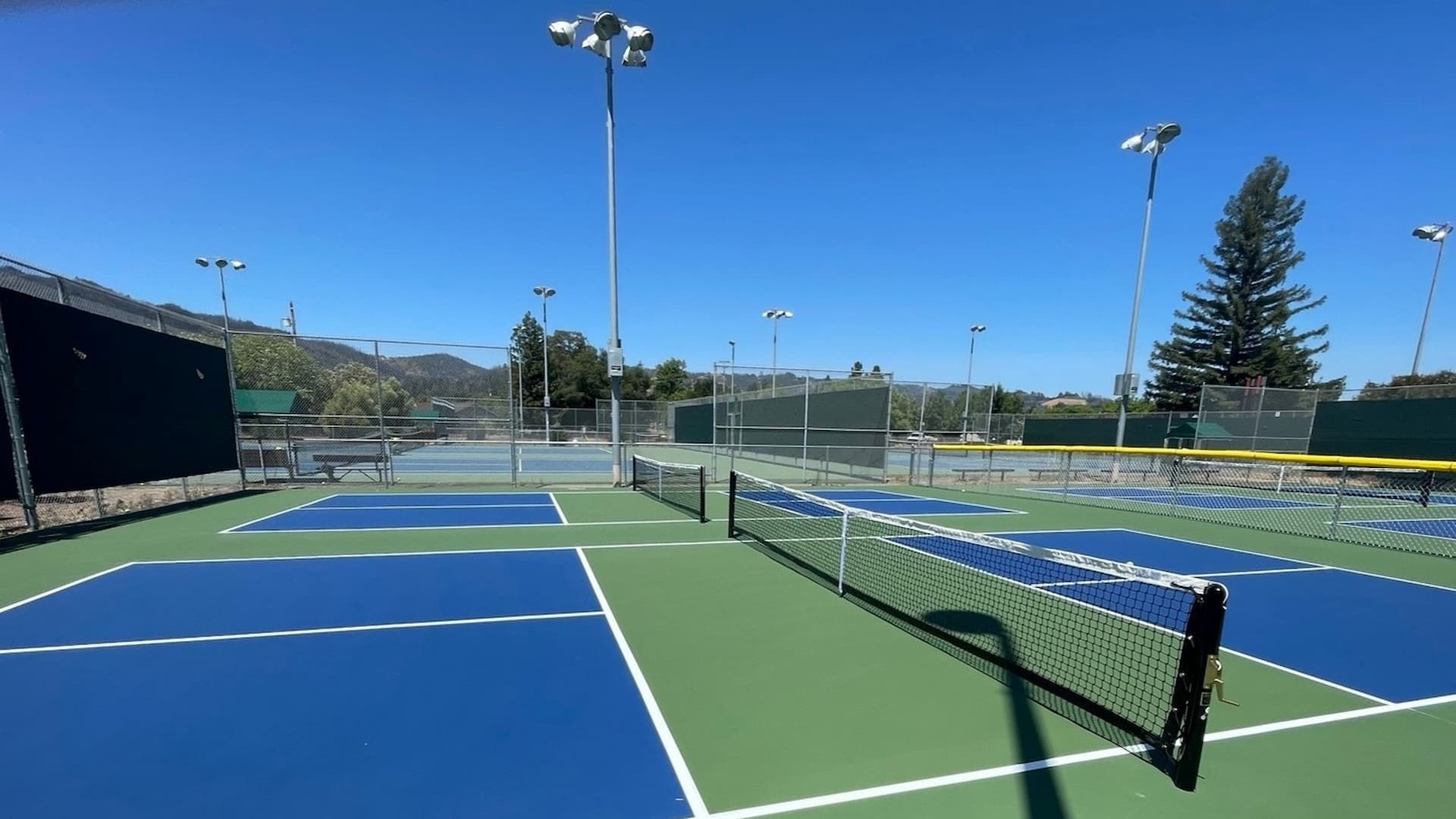 Outdoor pickleball courts under clear blue sky