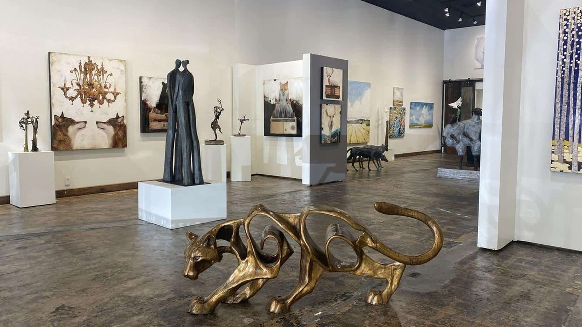 Contemporary art gallery with sculptures and paintings display.