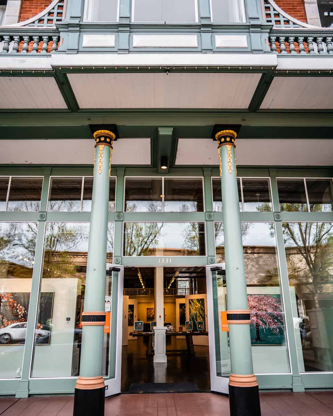 Art gallery entrance with glass doors and columns.