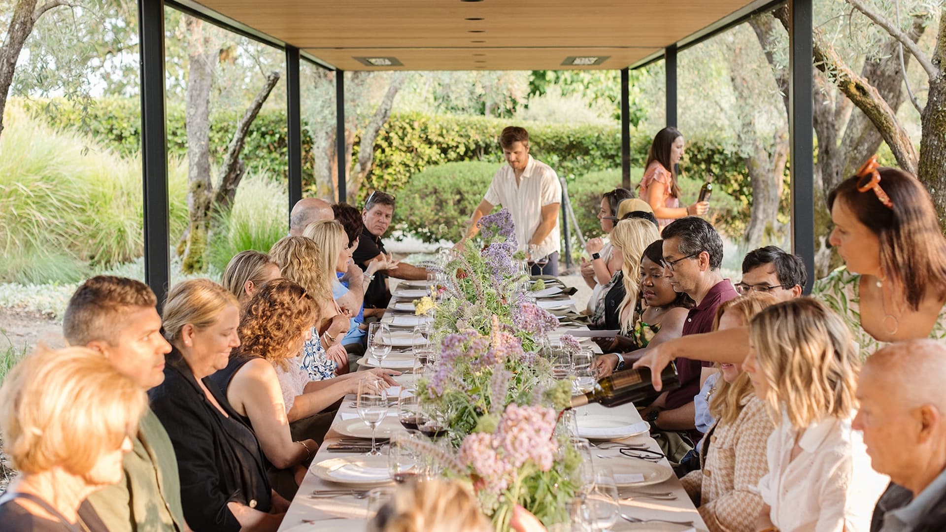 People dining outdoors at a long table.