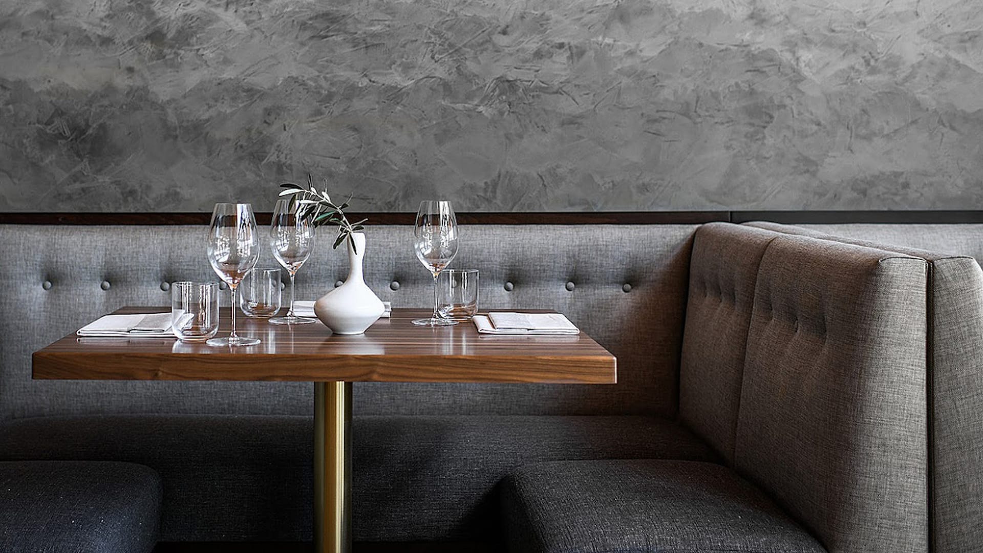Elegant restaurant booth with set dining table.