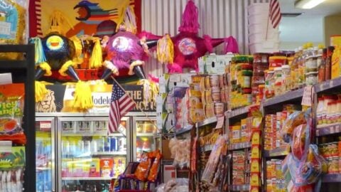 Mexican grocery store with colorful piñatas and products.
