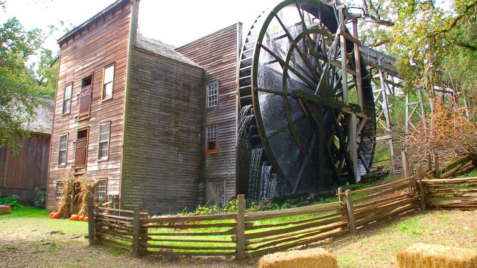 Historic watermill with large wooden wheel.