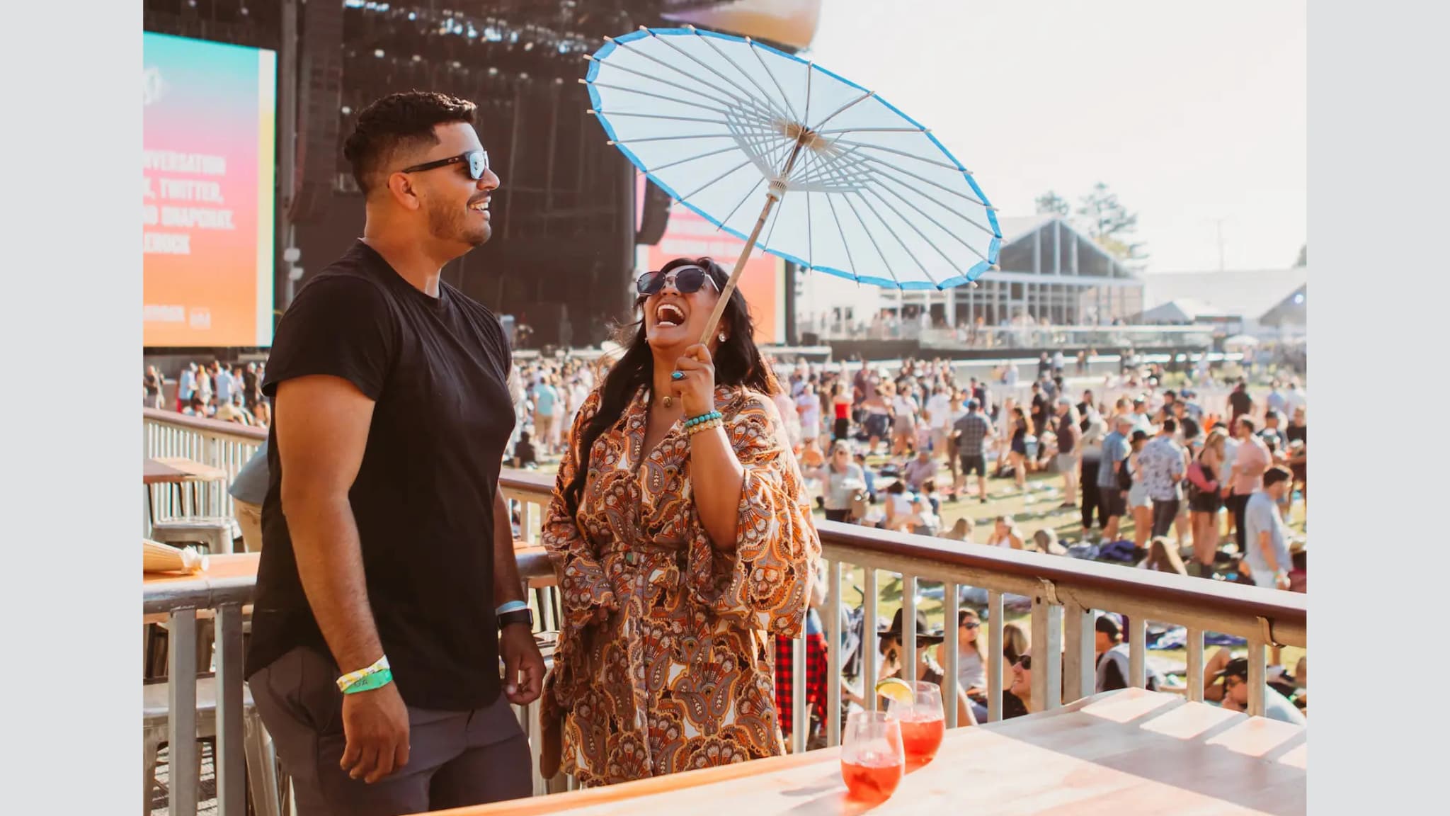Smiling couple with parasol at outdoor festival