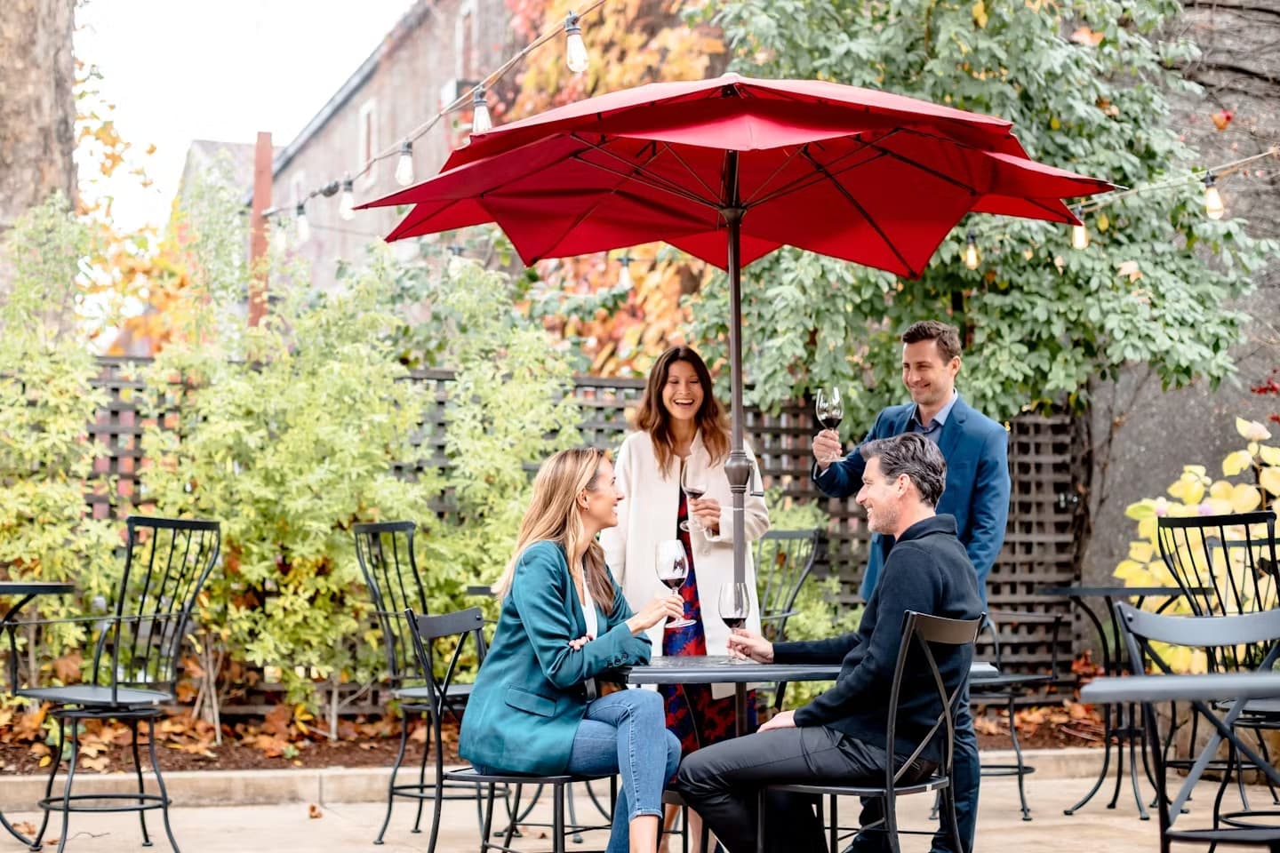 Friends enjoying wine at outdoor cafe table.