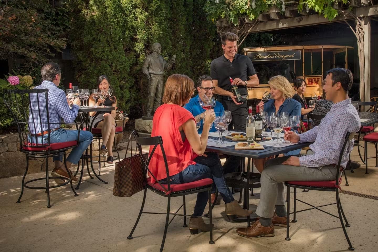 Group enjoying wine tasting at vineyard patio.