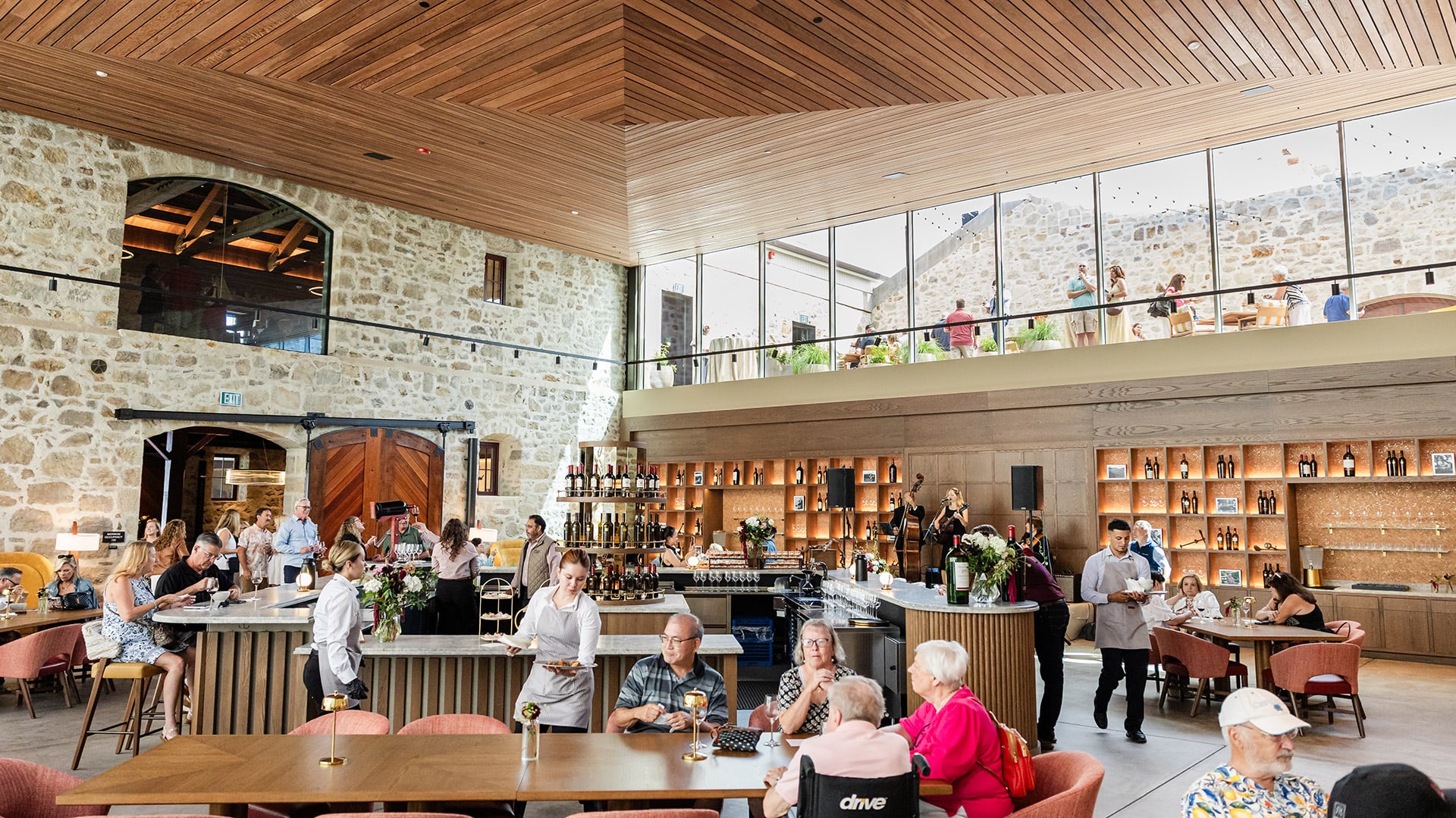 Busy upscale restaurant bar with diners and stone walls