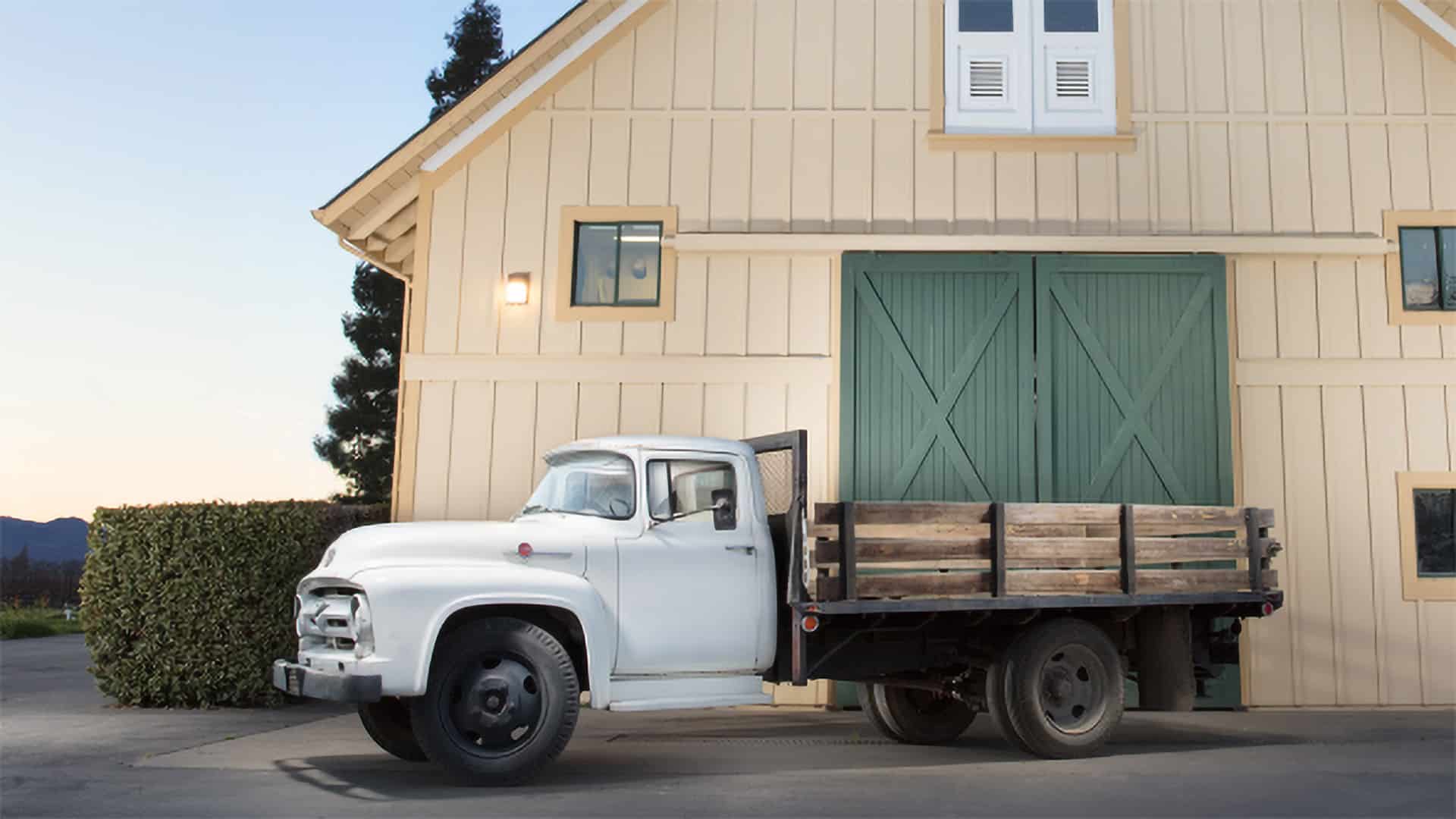 Vintage white truck in front of barn