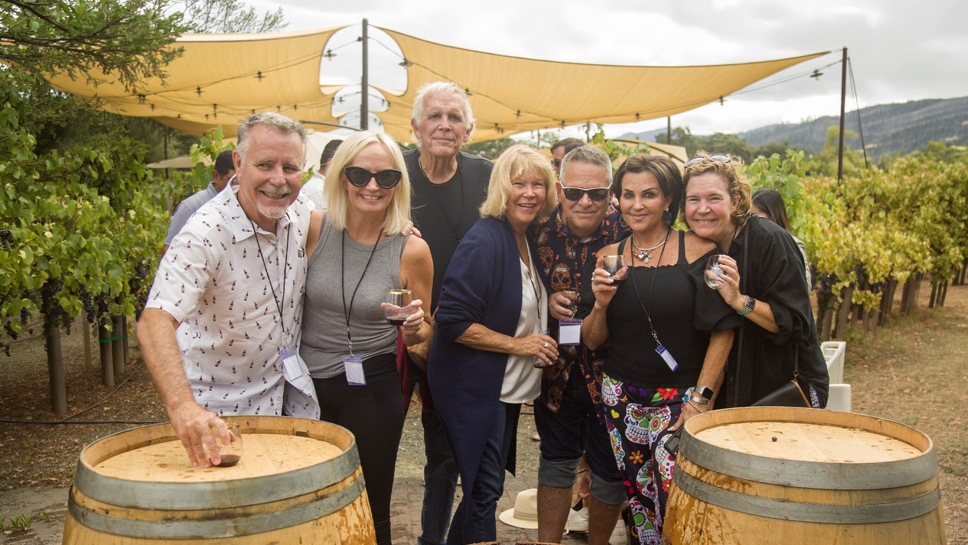 Friends posing with wine glasses at a vineyard event