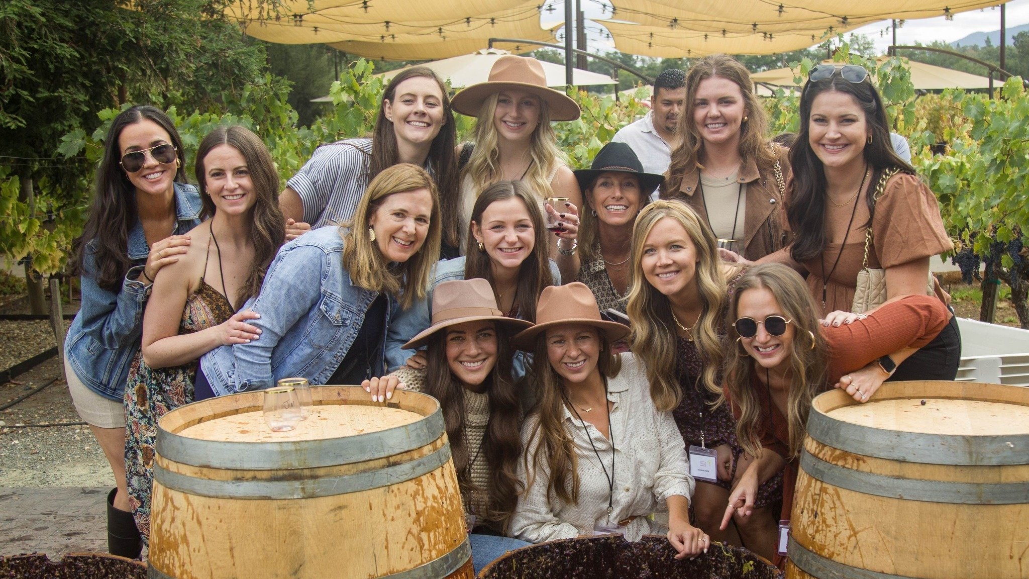 Group enjoying wine tasting at vineyard event.