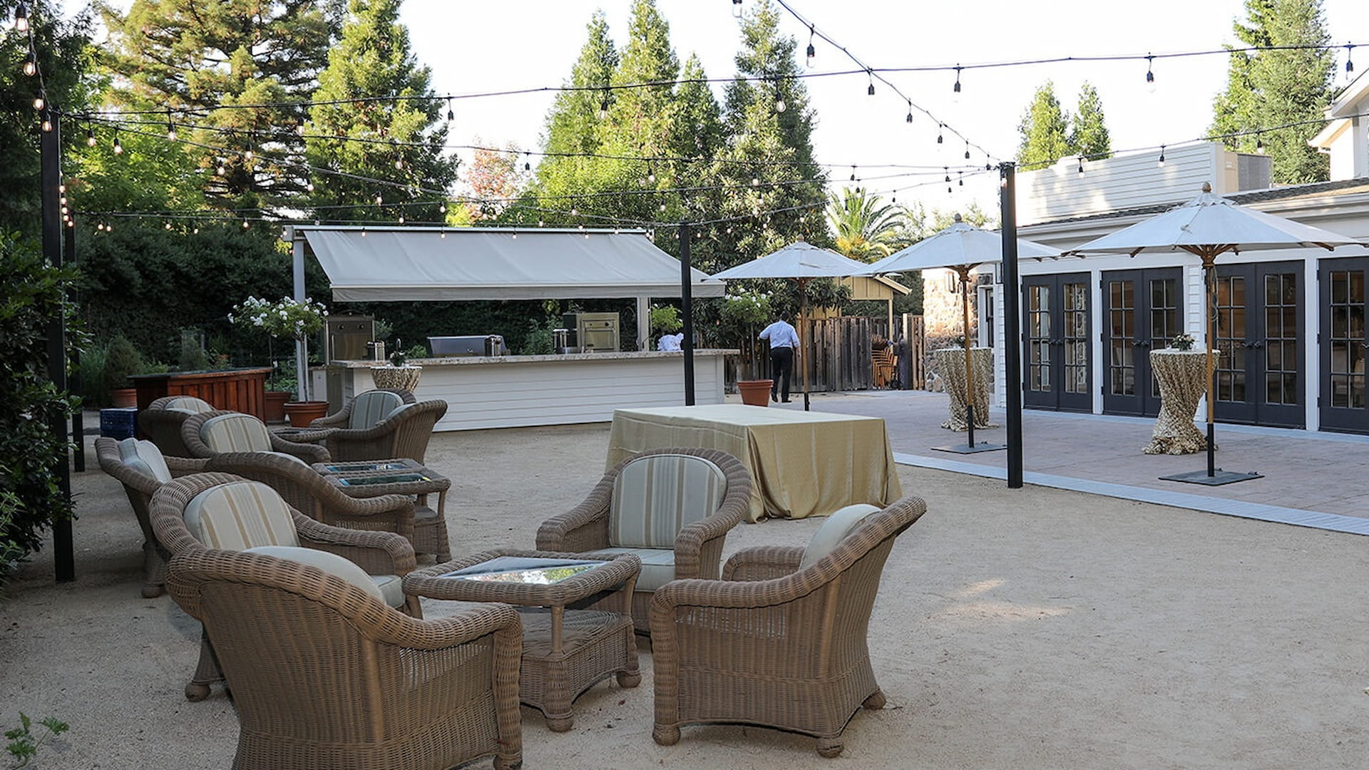 Outdoor patio with wicker chairs and string lights.