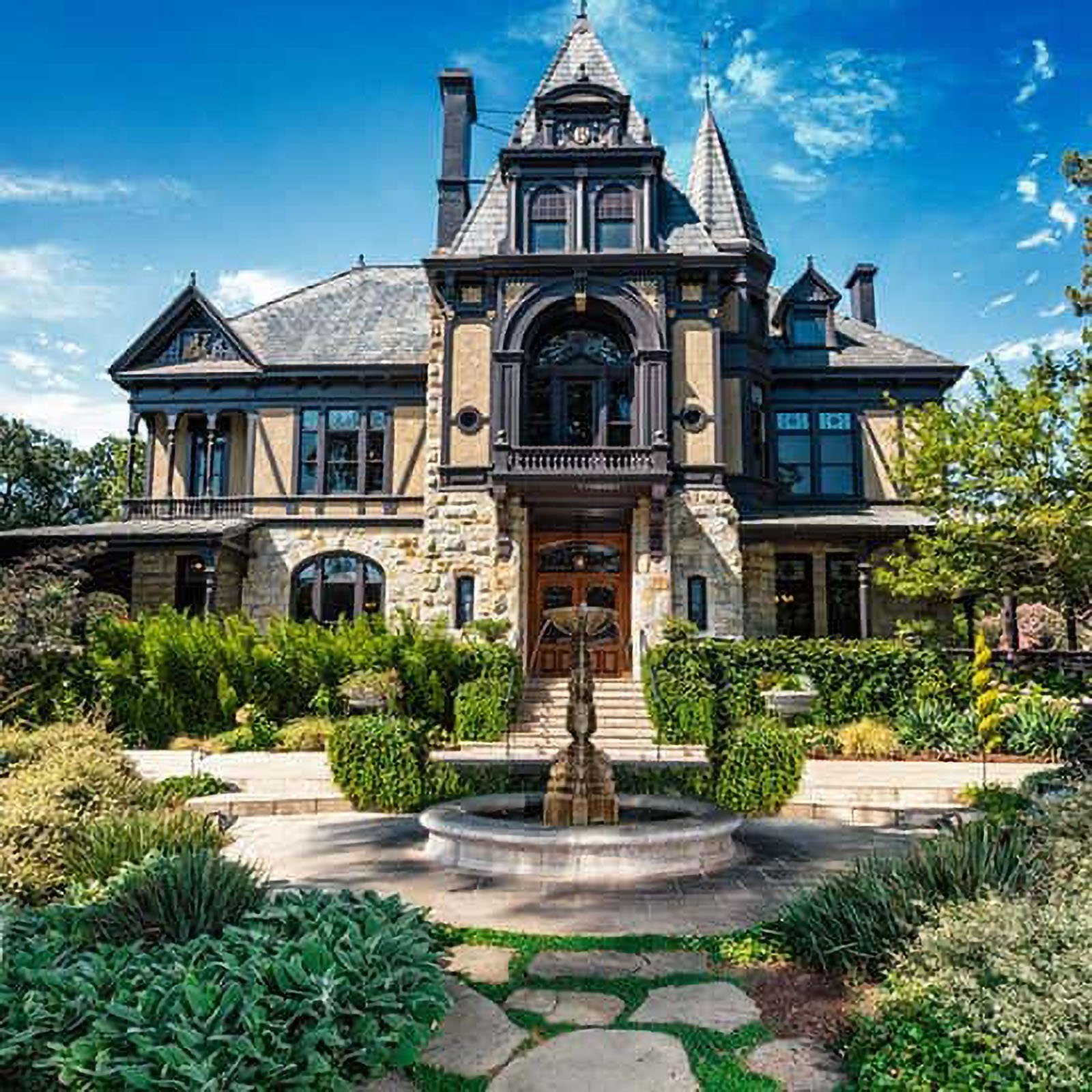 Victorian mansion with fountain and gardens