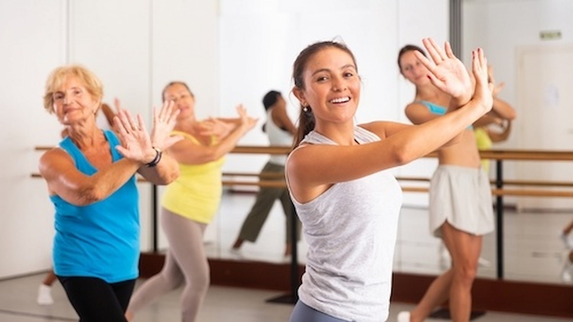 Group dance exercise class with smiling participants.