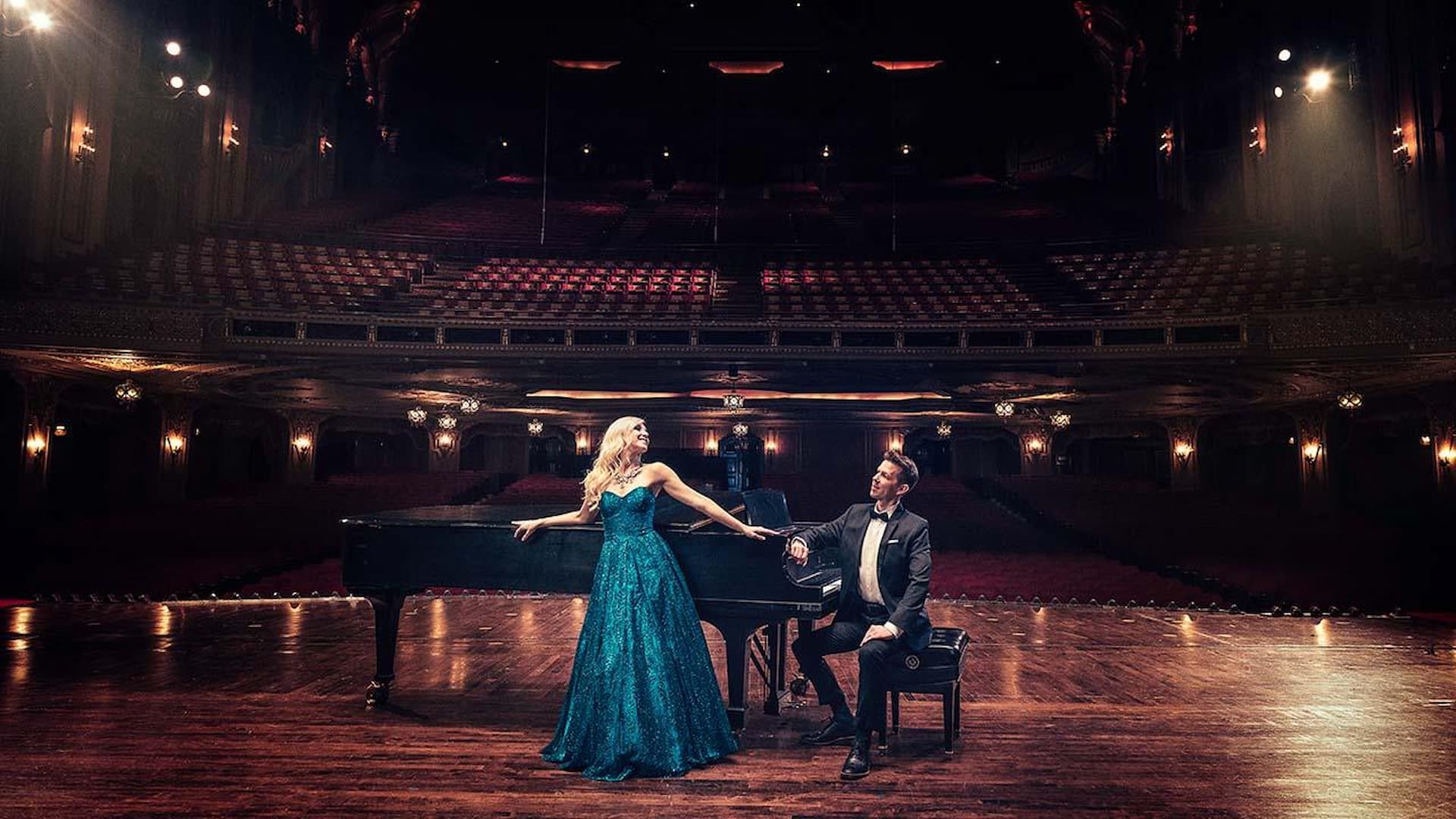 Elegant duo performing on grand theater stage.