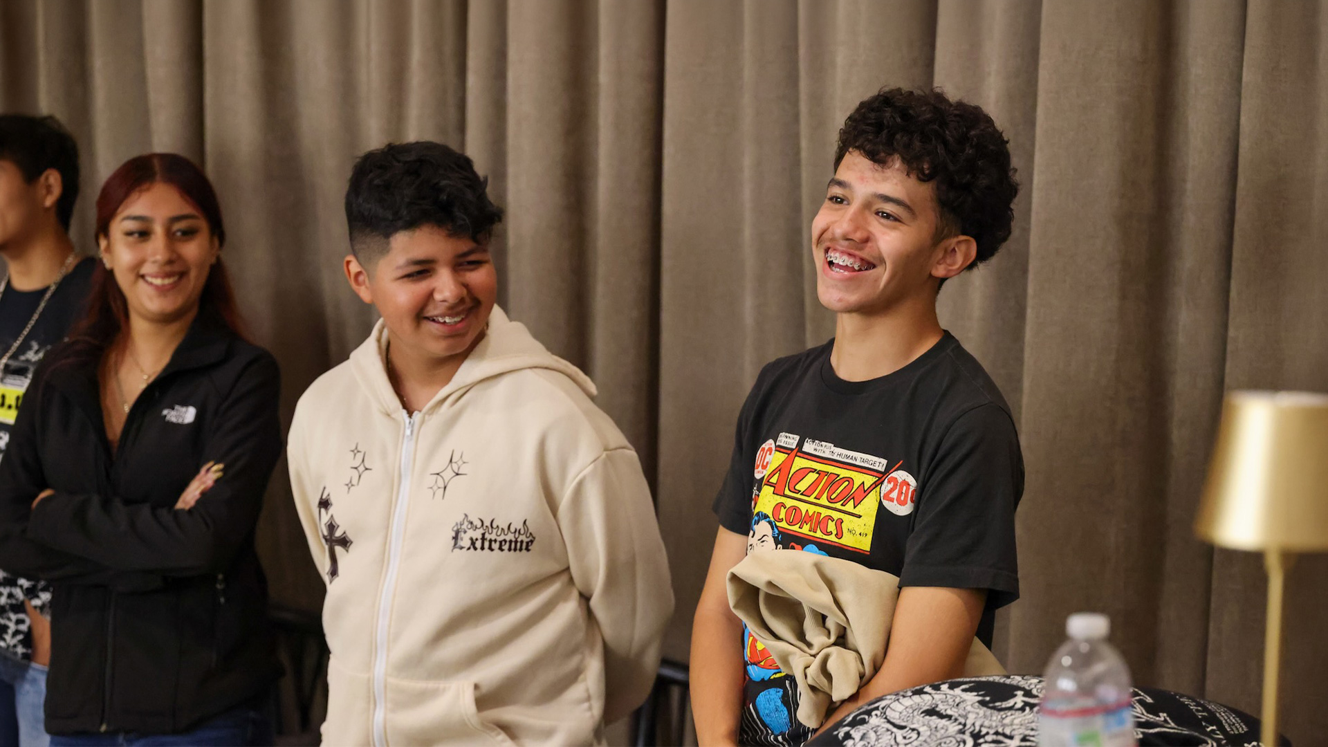 Smiling teenagers standing together in a room