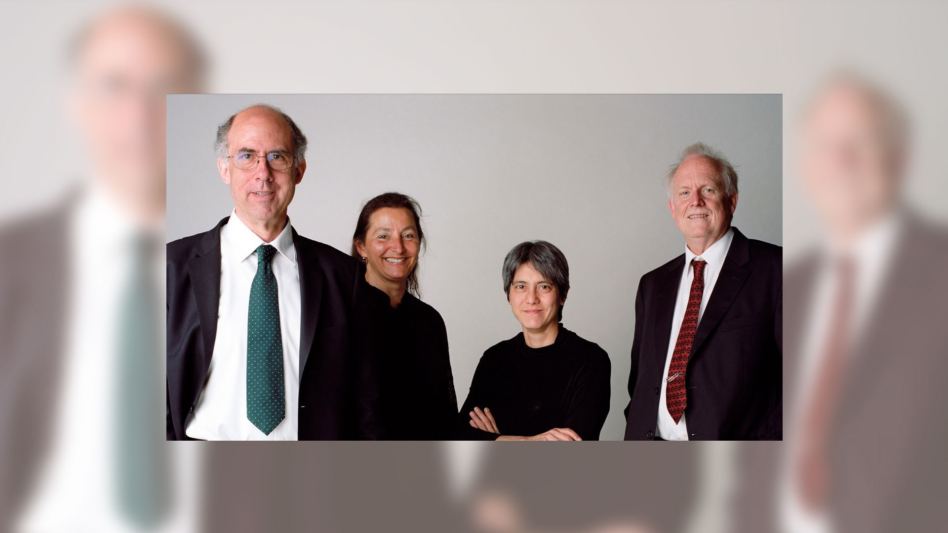 Four professionals posing in formal attire
