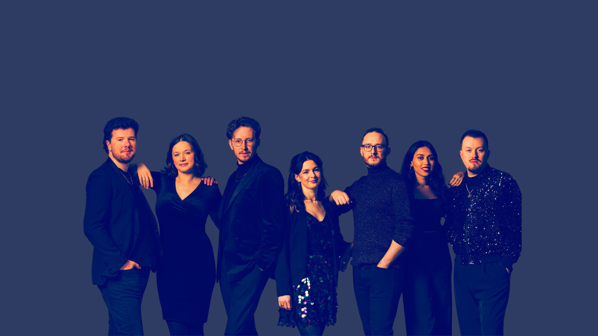 Seven adults posing in formal dark attire