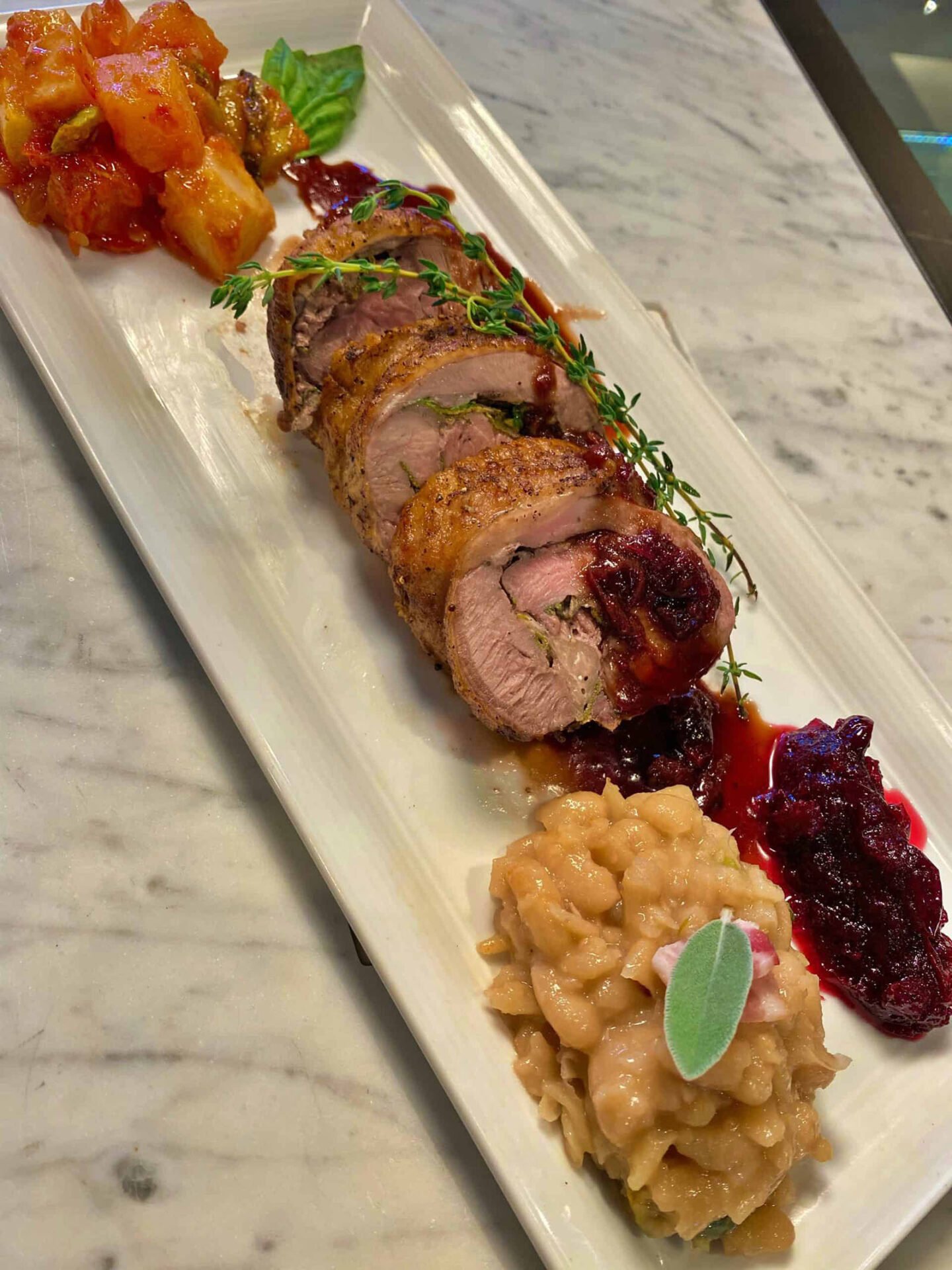 Stuffed pork tenderloin with sides.