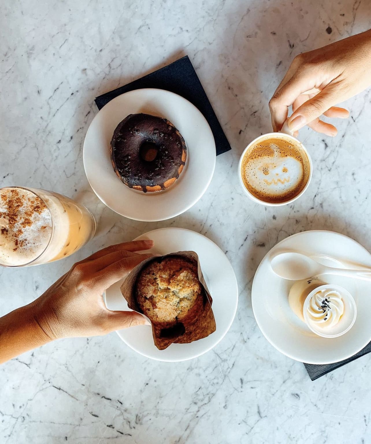 Coffee, donut, muffin, dessert on a marble table.