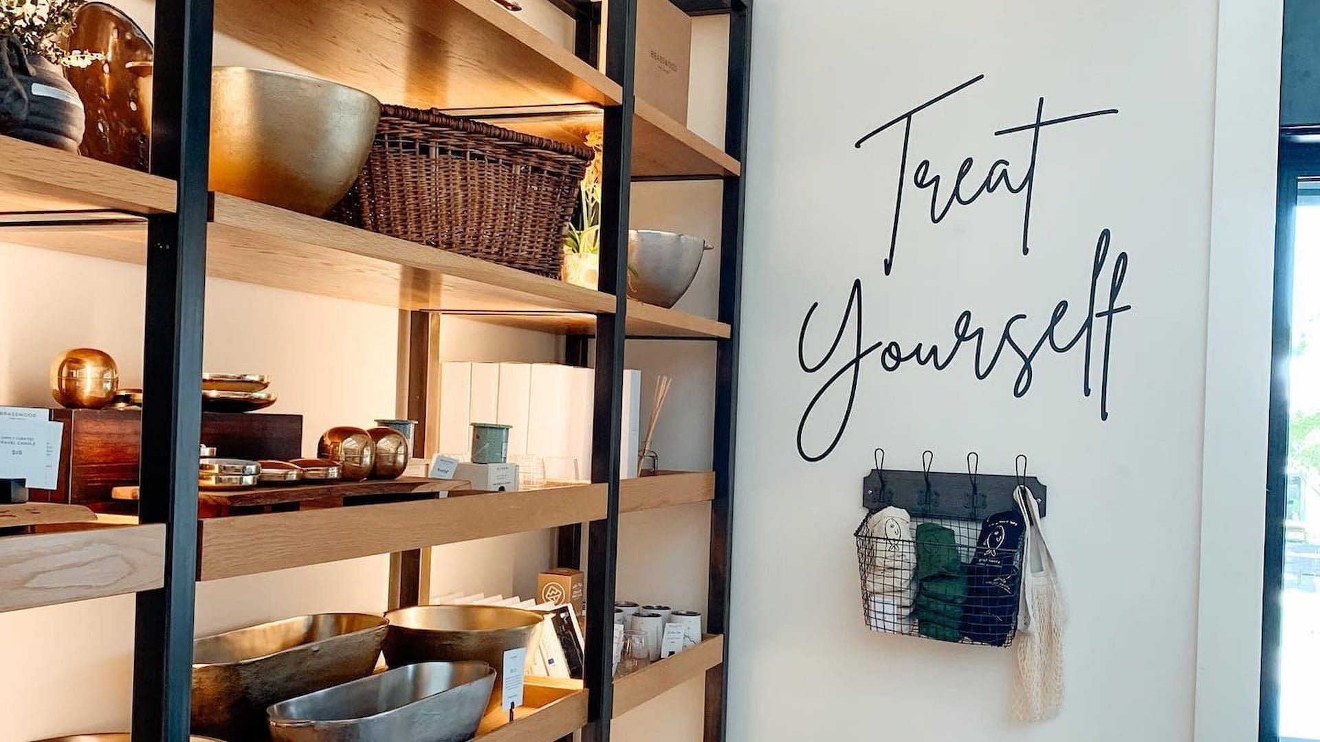 Shelves with bowls, baskets, and 'Treat Yourself' sign.
