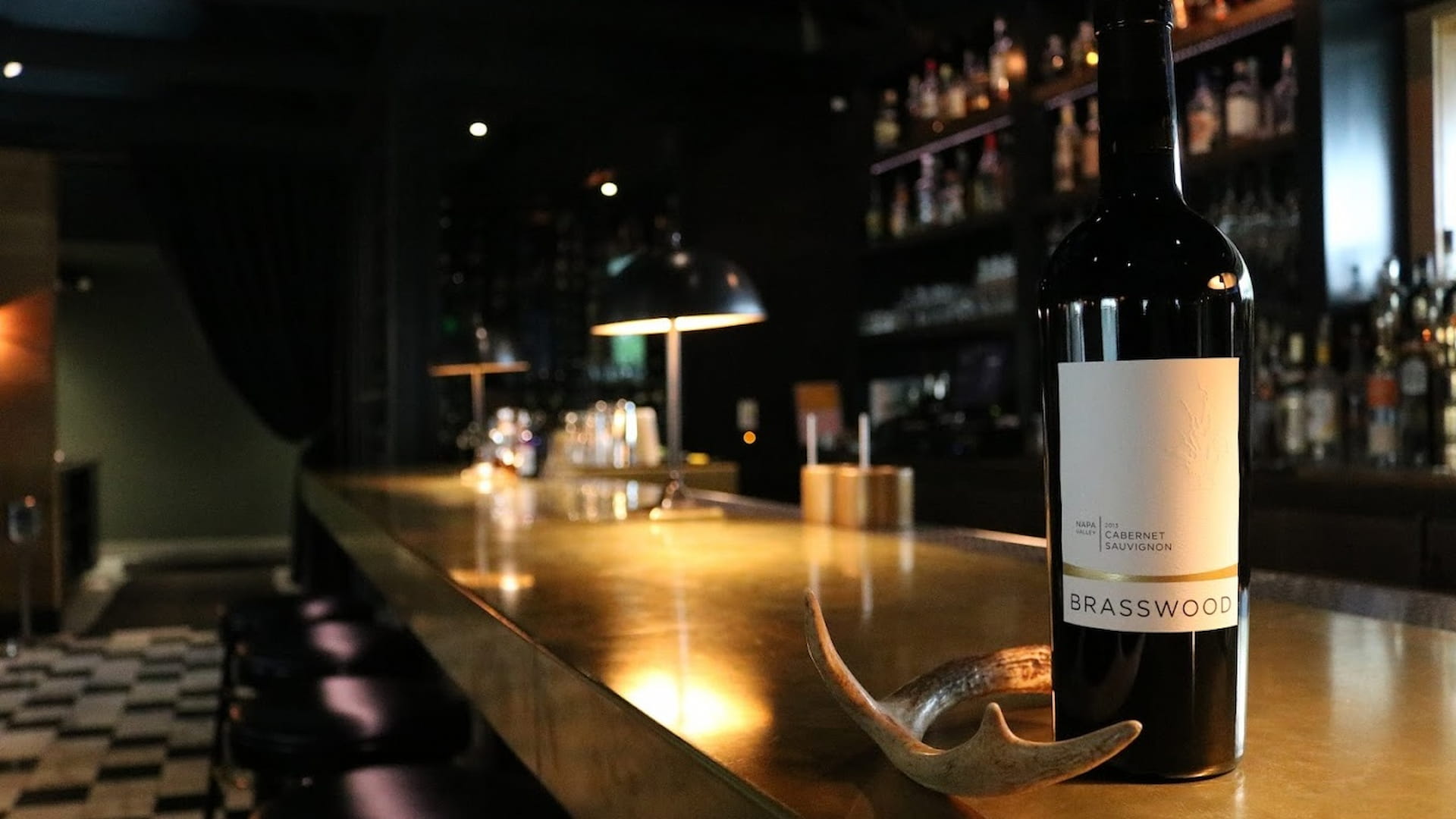 Bottle of wine on a dimly lit bar counter.