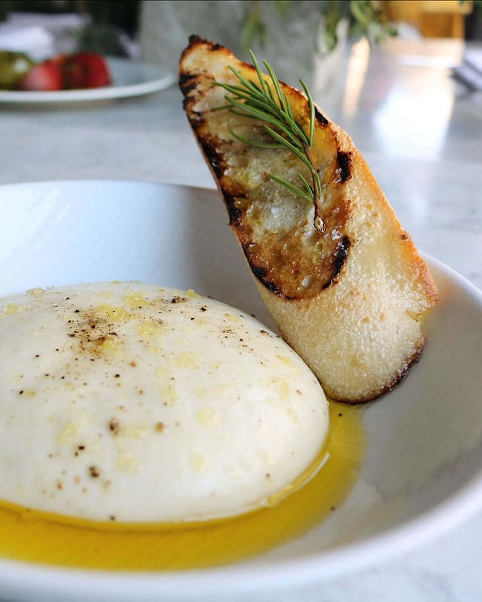 Creamy cheese with olive oil and grilled bread.
