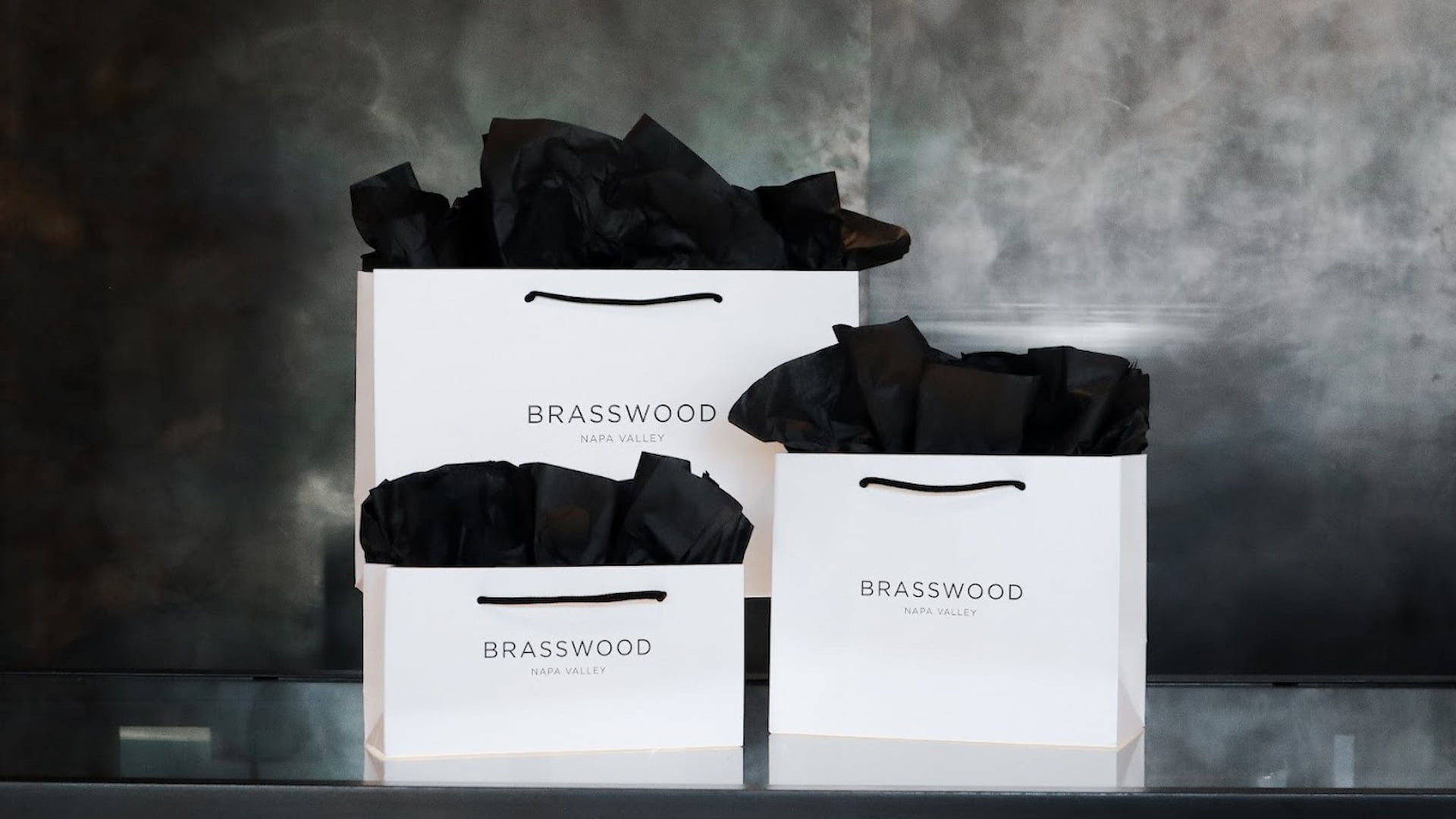 Brasswood Napa Valley shopping bags with black tissue paper.