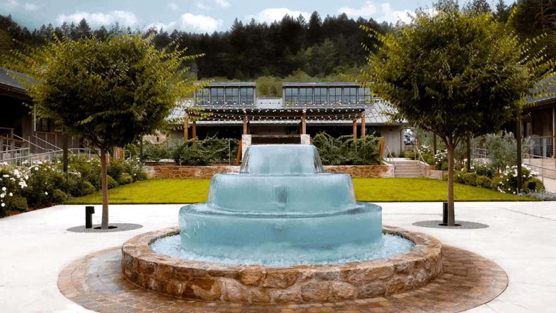 Elegant courtyard with fountain and trees.
