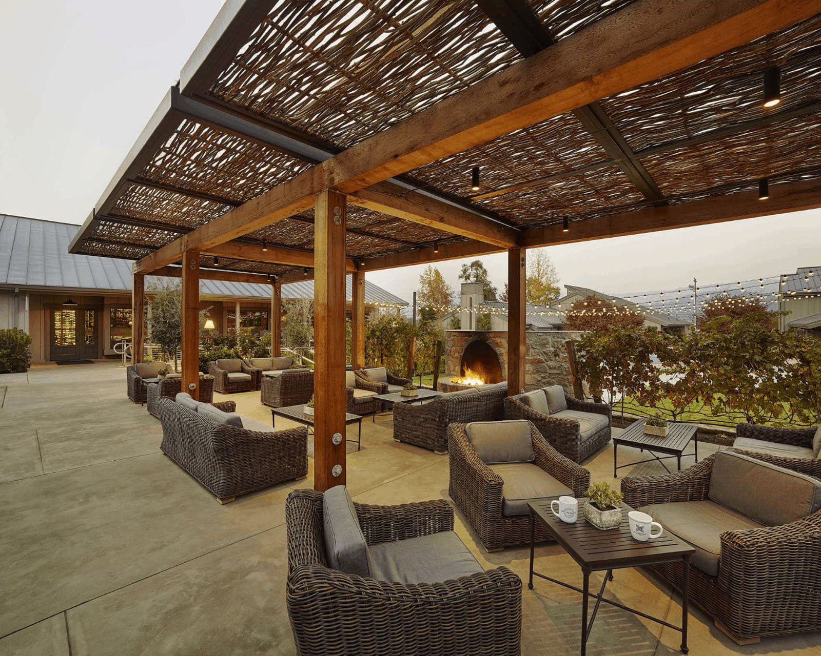 Outdoor patio with wicker furniture and fireplace.