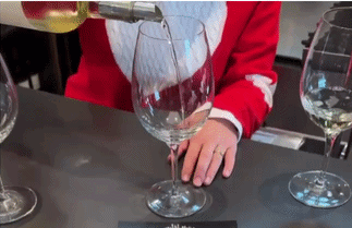 Person pouring white wine into a glass