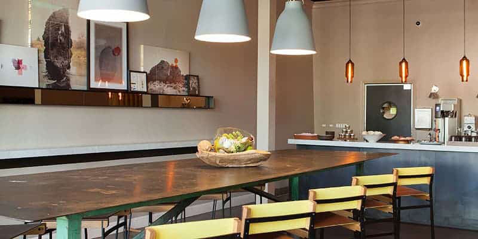 Modern restaurant interior with art and hanging lights.