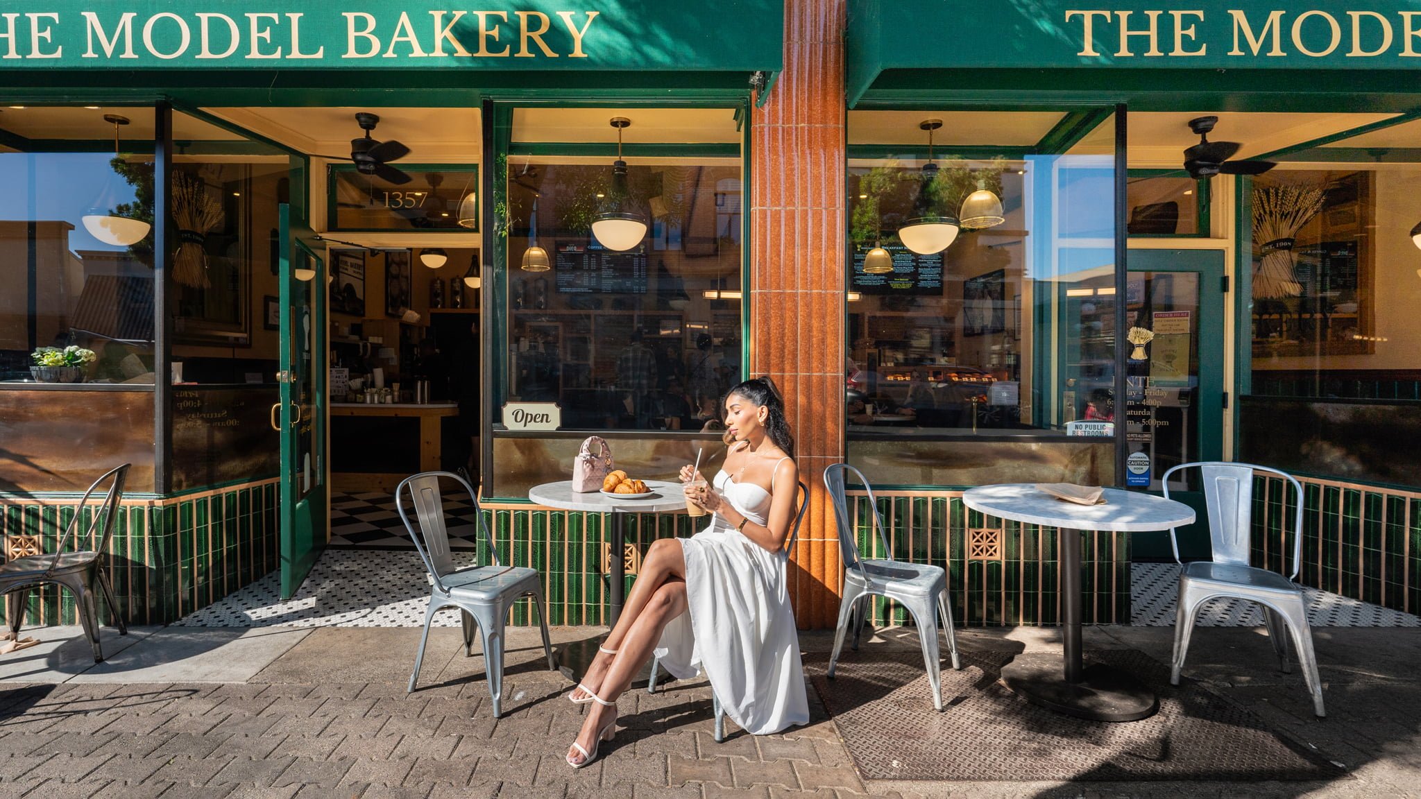 Woman enjoying coffee outside a bakery.