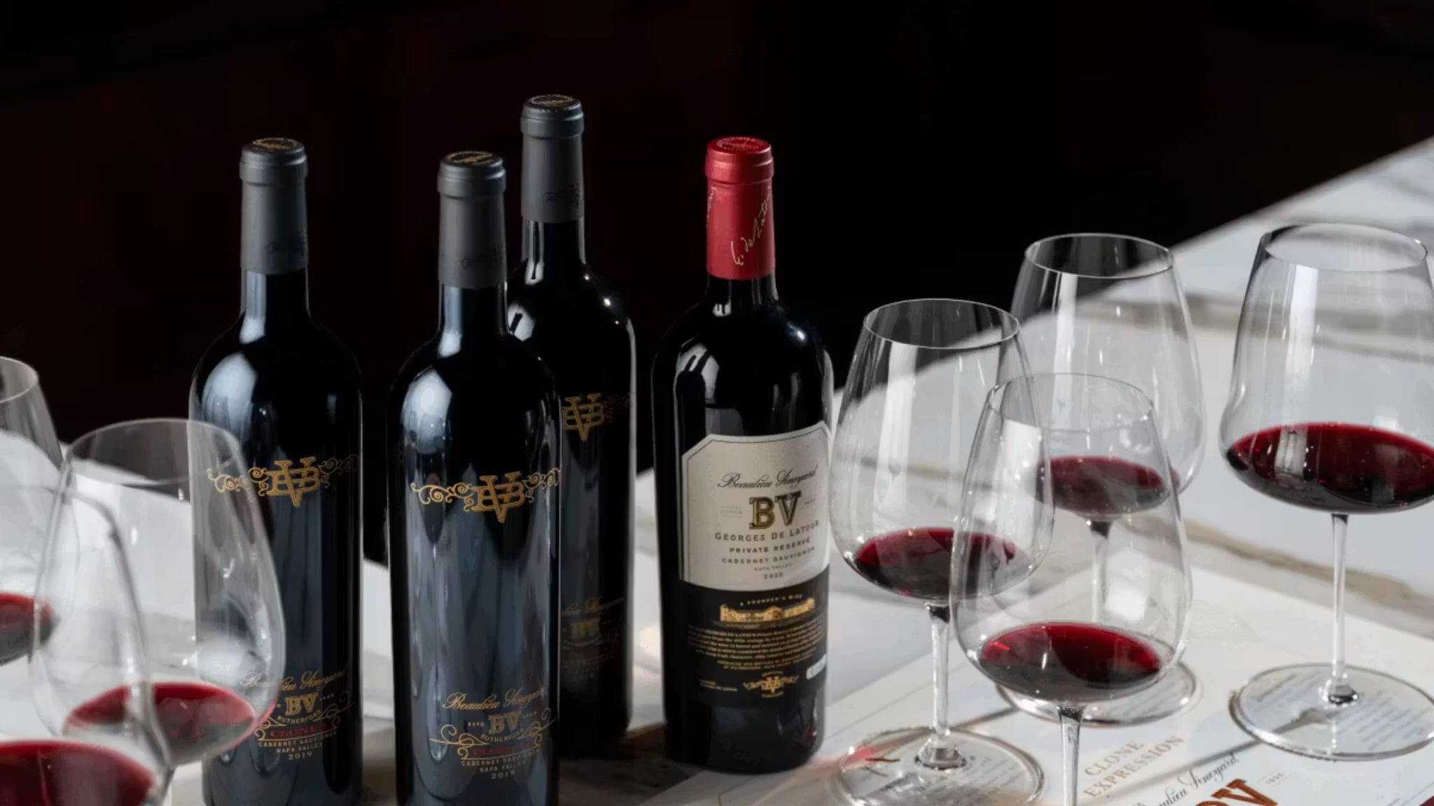 Red wine bottles and glasses on table