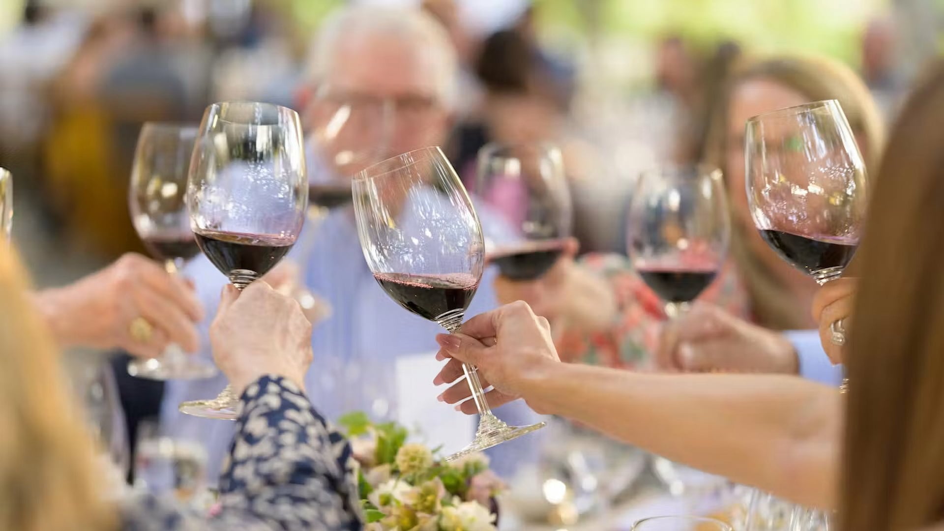 People toasting with glasses of red wine