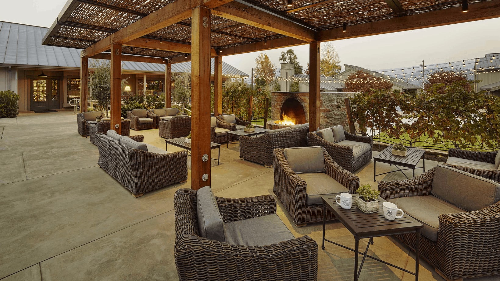 Outdoor patio with wicker furniture and fireplace.