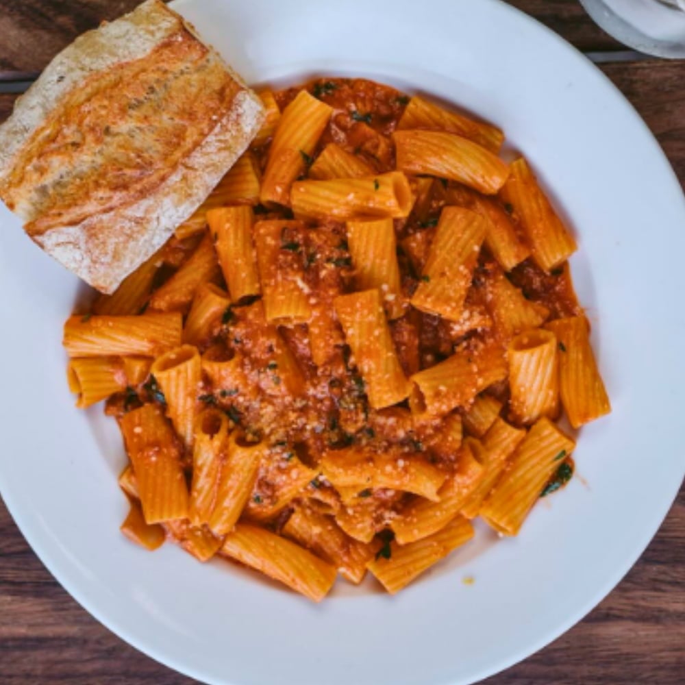 Rigatoni pasta with tomato meat sauce and bread