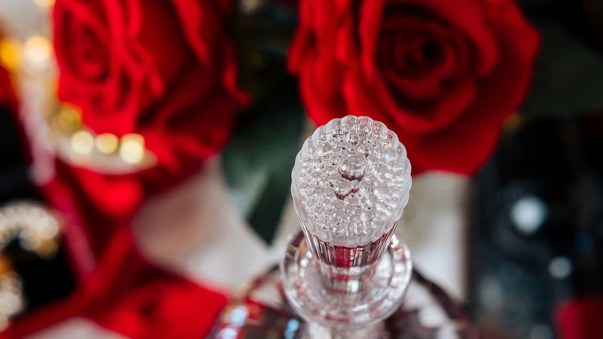 Crystal bottle surrounded by red roses