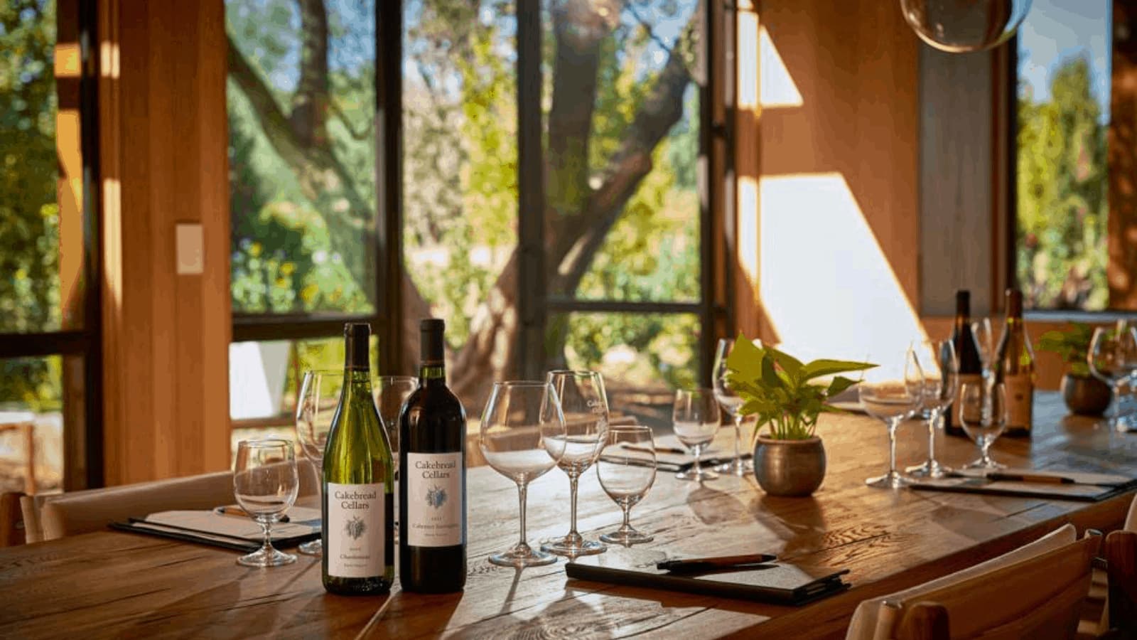 Wine bottles and glasses on wooden table.