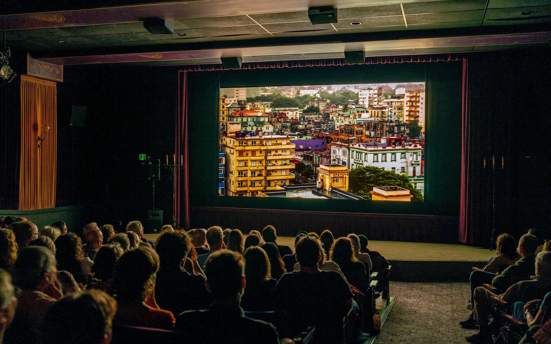 Audience watching cityscape movie in theater.