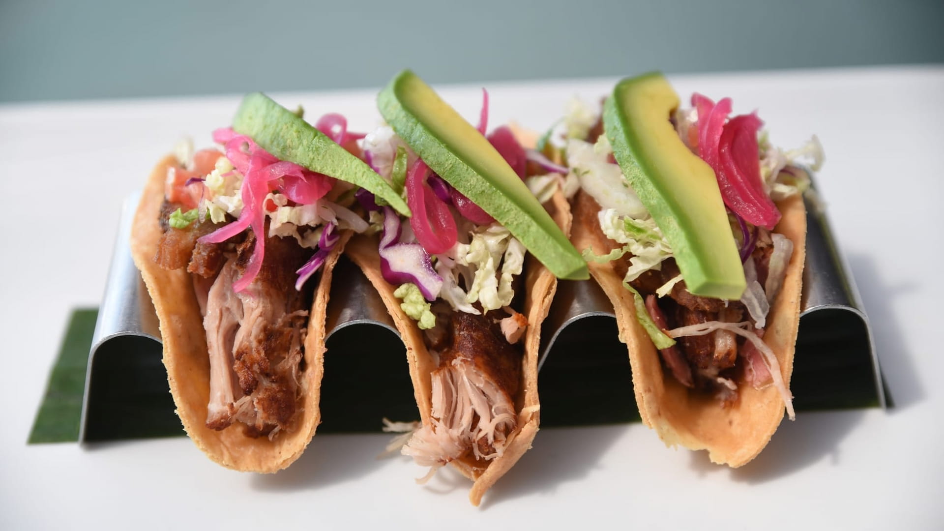Three tacos with avocado and pickled vegetables