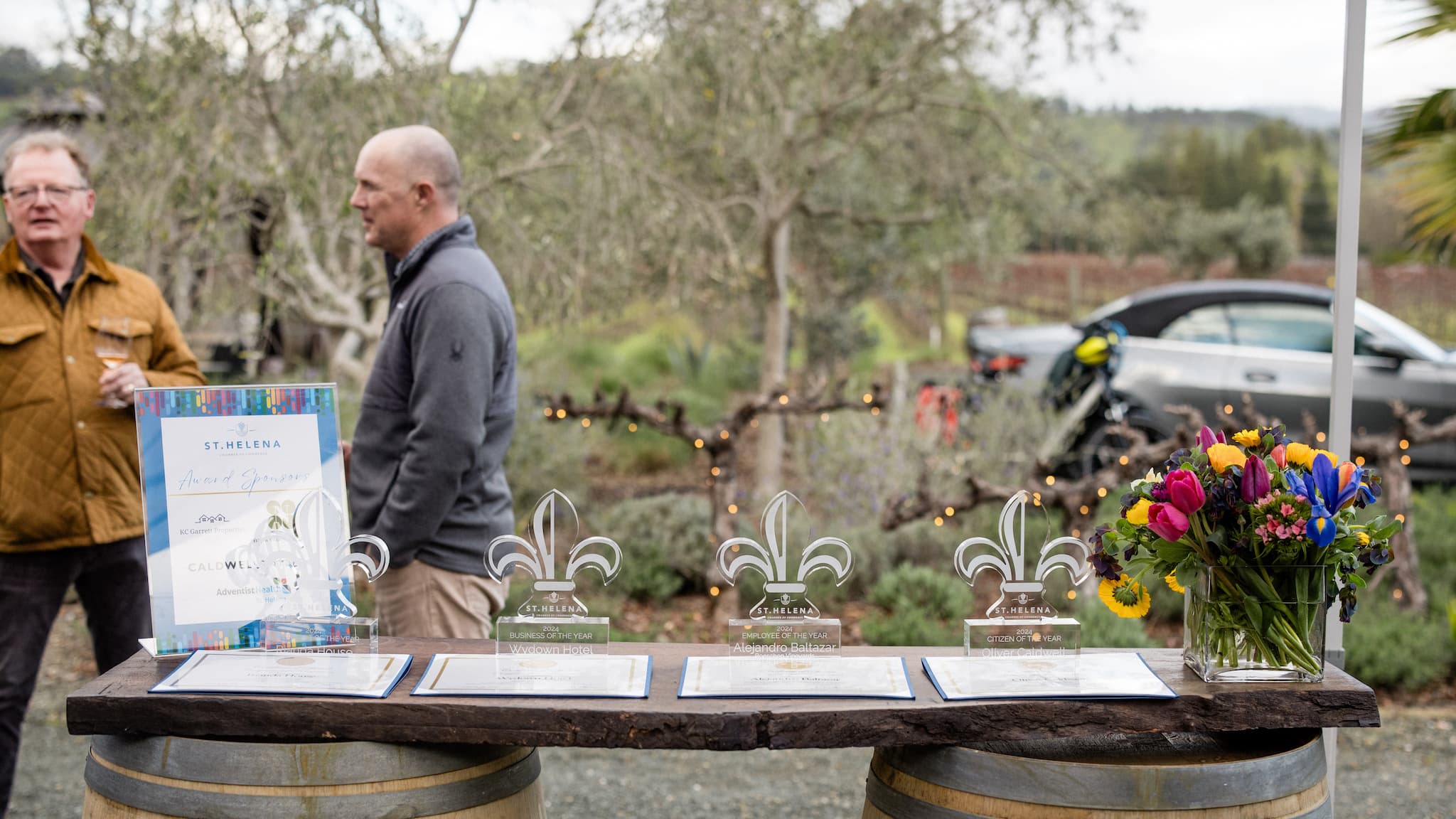 Award display with flowers and people outdoors