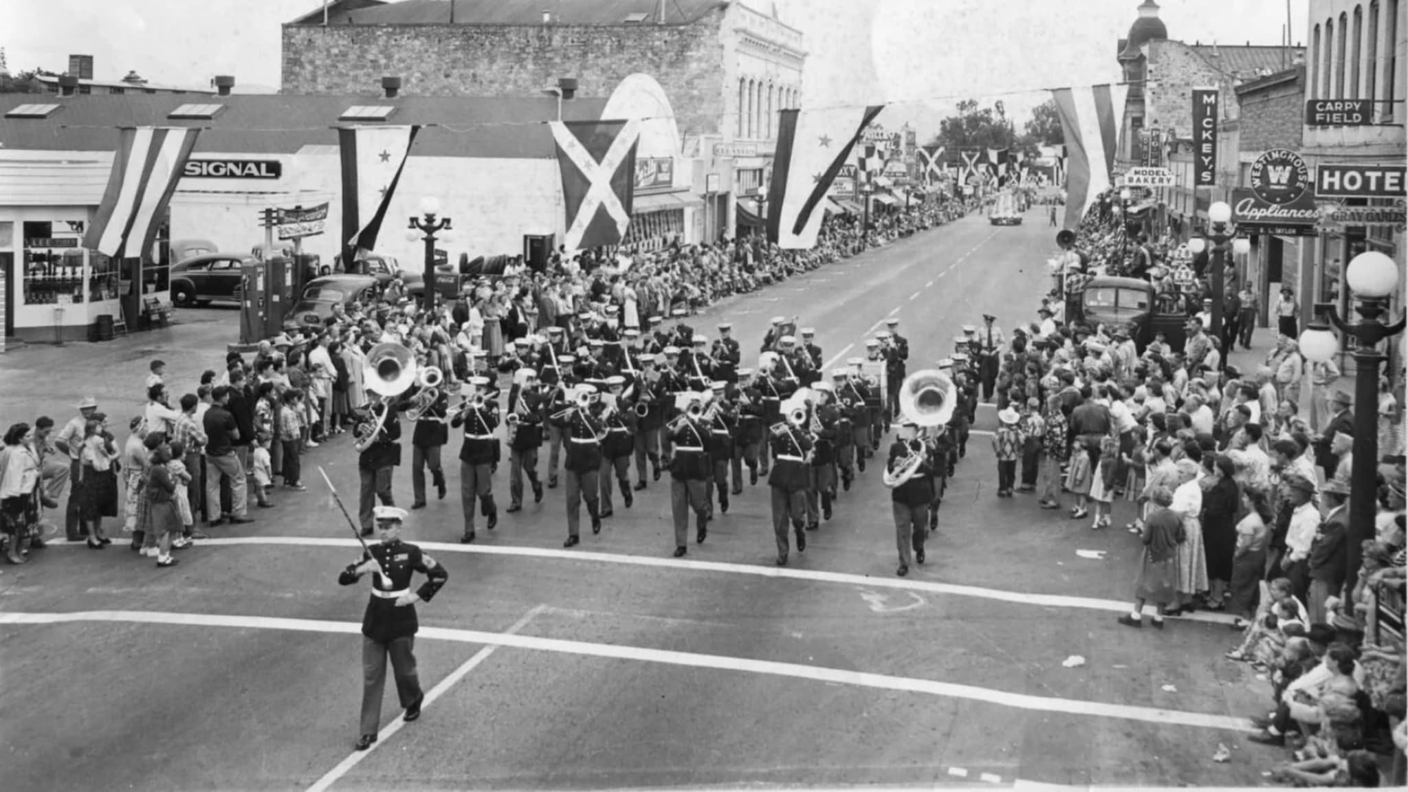 Marching band parade through crowded downtown street