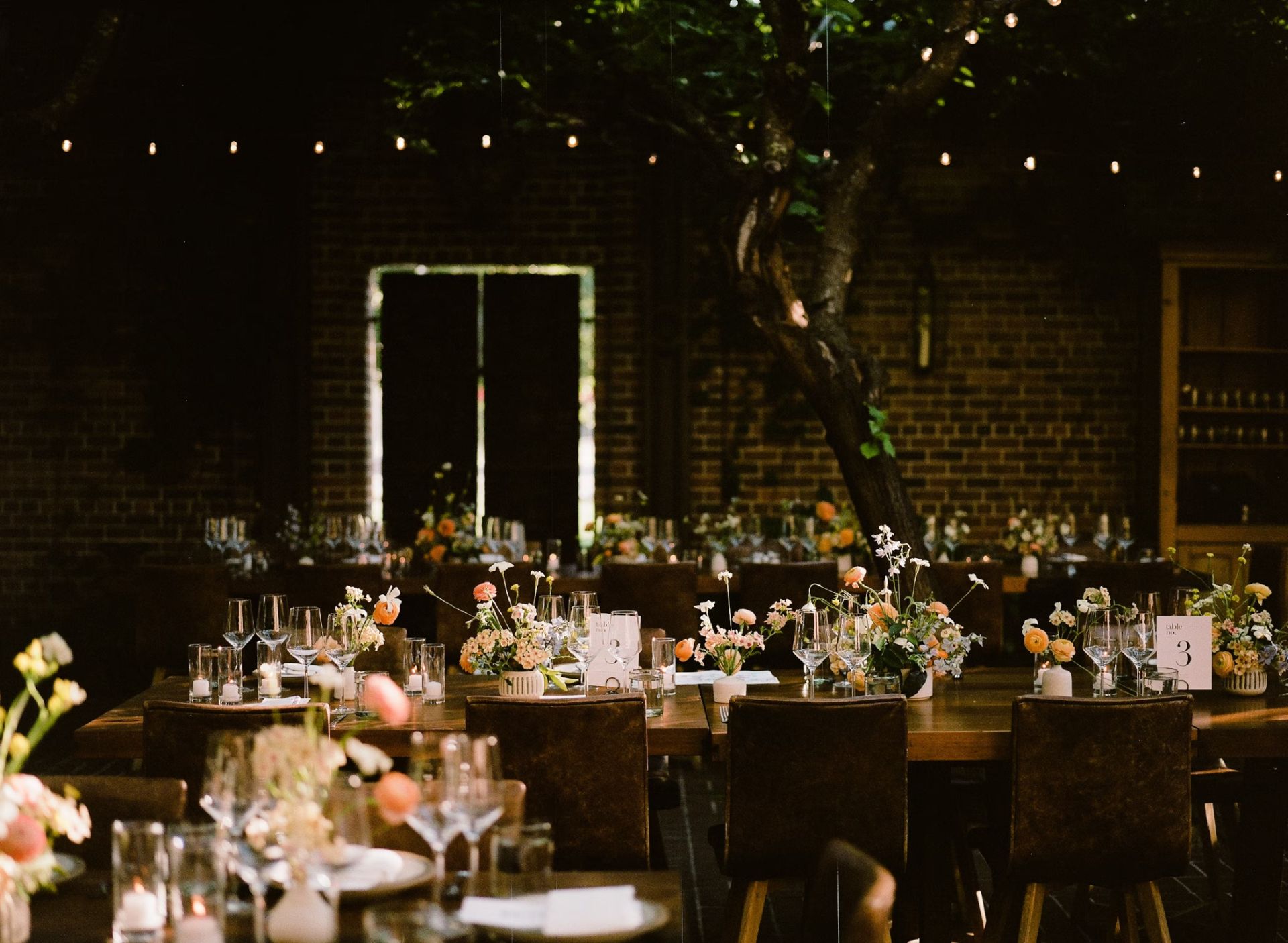 Elegant outdoor wedding reception with floral centerpieces.