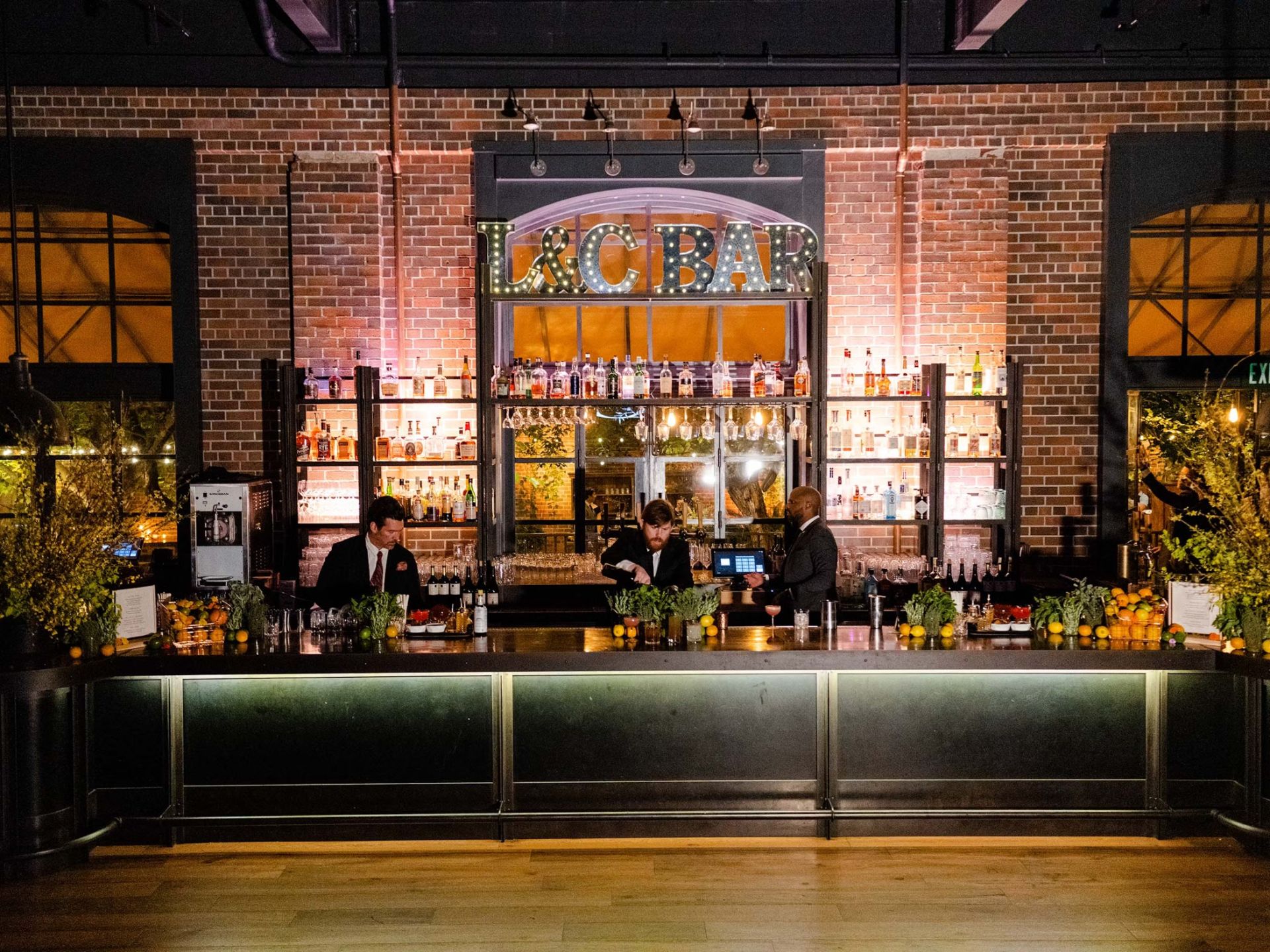 Elegant bar with shelves of spirits and bartenders.